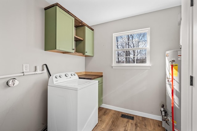 laundry area featuring cabinet space, baseboards, washer / clothes dryer, wood finished floors, and water heater