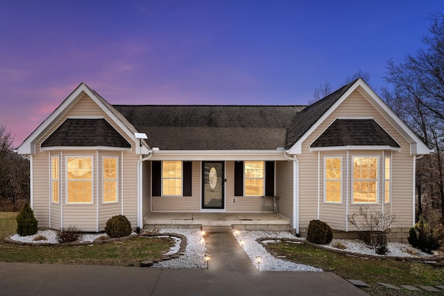 ranch-style home featuring a porch and roof with shingles