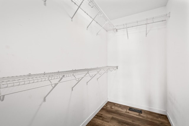 spacious closet with visible vents and dark wood-type flooring