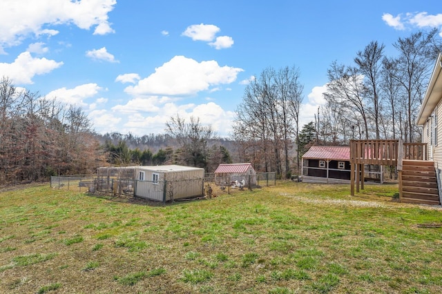 view of yard with an outbuilding, fence, and exterior structure