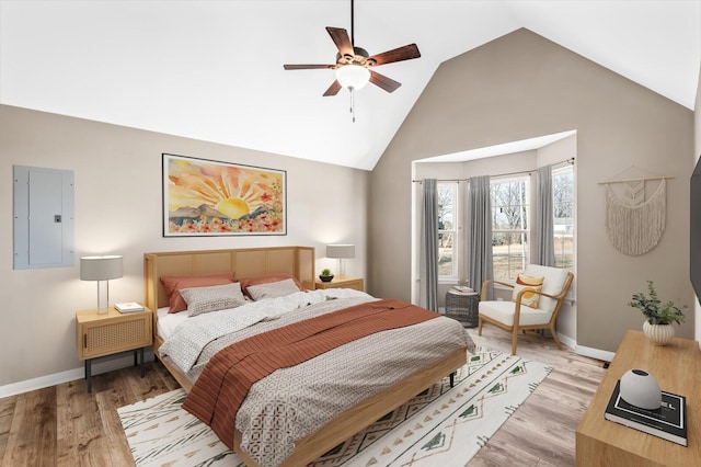 bedroom featuring high vaulted ceiling, light wood finished floors, electric panel, and baseboards