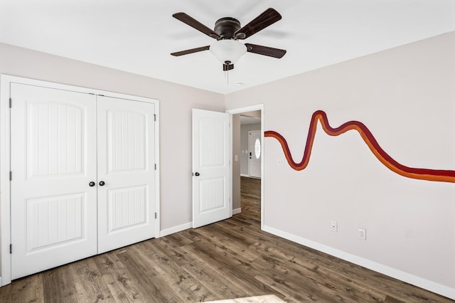 unfurnished bedroom with ceiling fan, a closet, baseboards, and wood finished floors