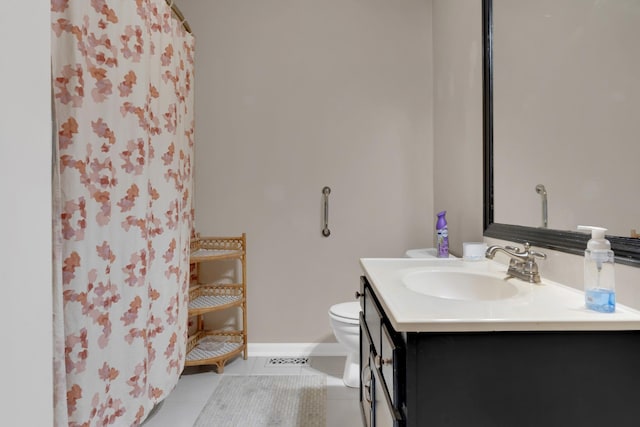 bathroom featuring vanity, tile patterned flooring, toilet, and walk in shower