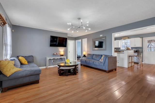 living room with an inviting chandelier and light hardwood / wood-style flooring