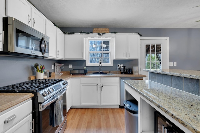 kitchen featuring white cabinetry, sink, and appliances with stainless steel finishes