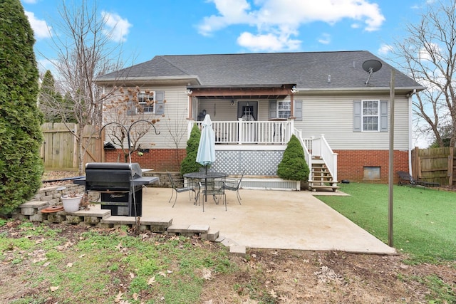 back of house with a patio and a lawn