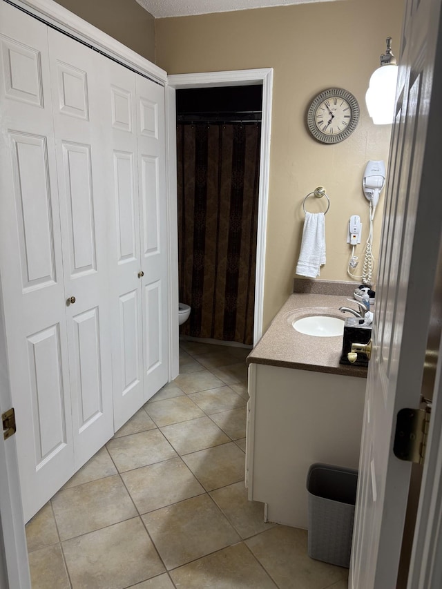 bathroom featuring tile patterned flooring, vanity, a shower with curtain, and toilet