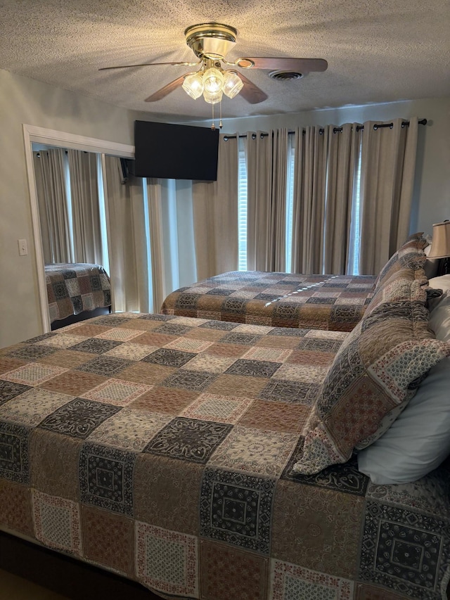 bedroom featuring ceiling fan and a textured ceiling