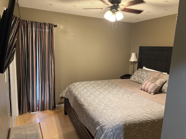 bedroom featuring hardwood / wood-style floors, a textured ceiling, and ceiling fan