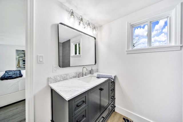 bathroom featuring vanity, a healthy amount of sunlight, and hardwood / wood-style floors