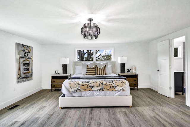 bedroom with a notable chandelier and hardwood / wood-style flooring