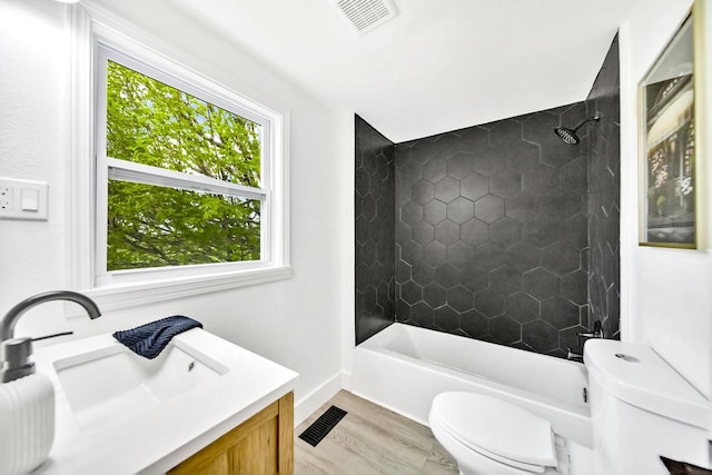 full bathroom with hardwood / wood-style flooring, vanity, toilet, and tiled shower / bath combo