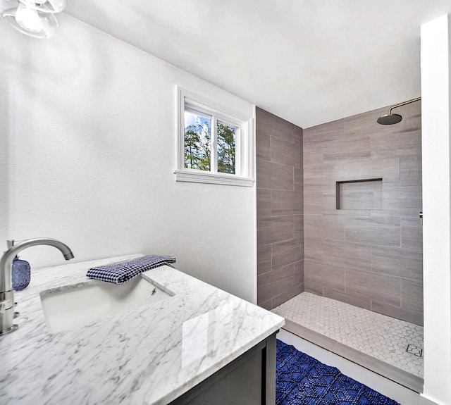 bathroom with vanity and a tile shower