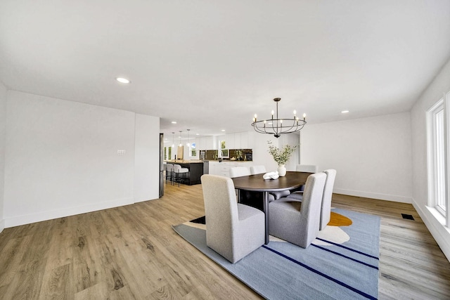 dining room featuring an inviting chandelier and light wood-type flooring