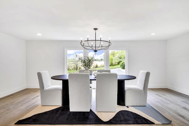 dining area with a chandelier and light hardwood / wood-style flooring