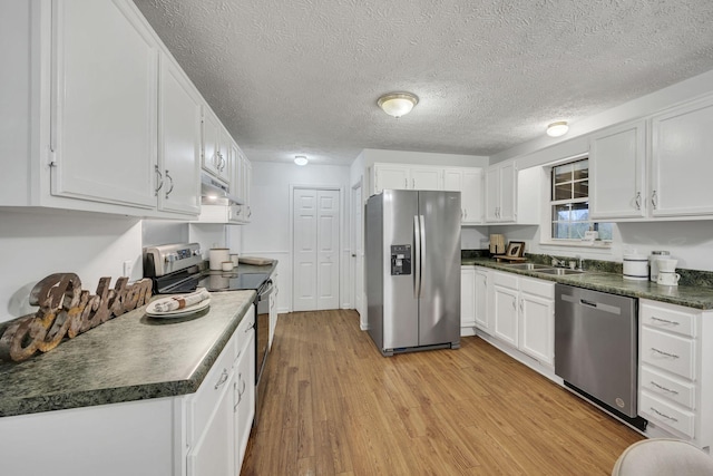 kitchen with white cabinetry, appliances with stainless steel finishes, and light wood-type flooring