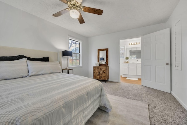 carpeted bedroom with ceiling fan, a textured ceiling, and ensuite bathroom