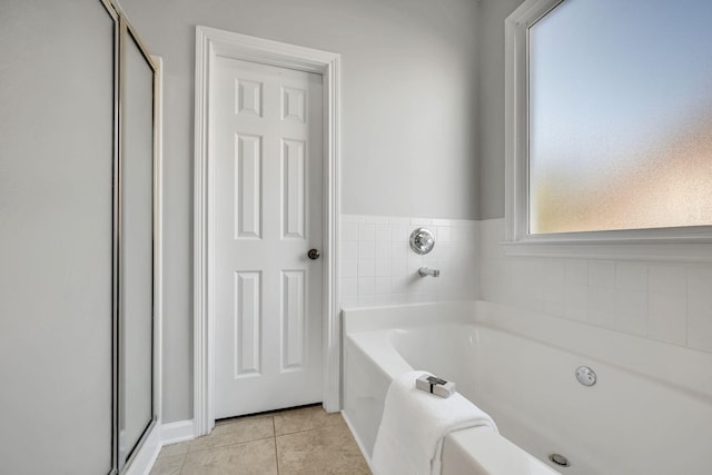 bathroom with tile patterned floors and a bathing tub