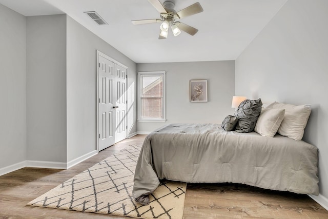 bedroom with ceiling fan, hardwood / wood-style floors, and a closet