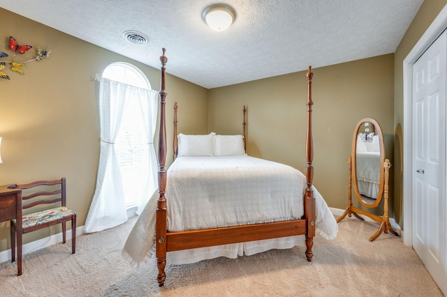 carpeted bedroom with a textured ceiling and a closet