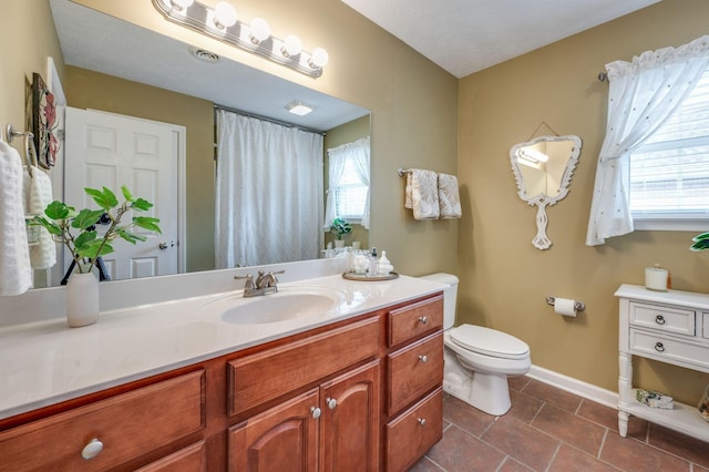 bathroom featuring vanity, tile patterned floors, and toilet