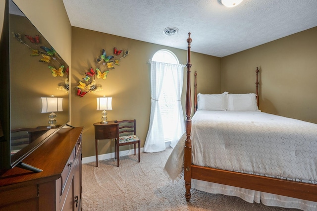 bedroom featuring light carpet and a textured ceiling