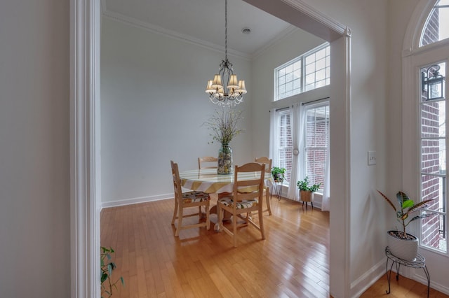 dining area featuring an inviting chandelier, ornamental molding, and light hardwood / wood-style floors