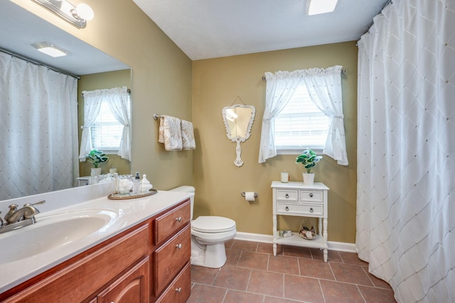 bathroom with tile patterned flooring, vanity, and toilet