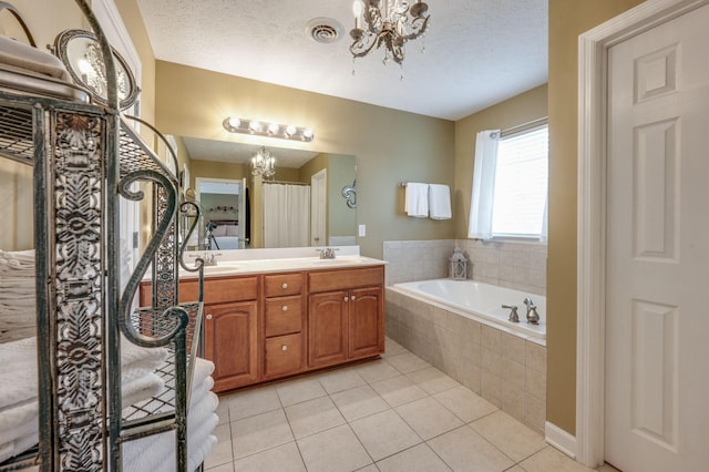 bathroom with tile patterned flooring, vanity, a textured ceiling, and a chandelier