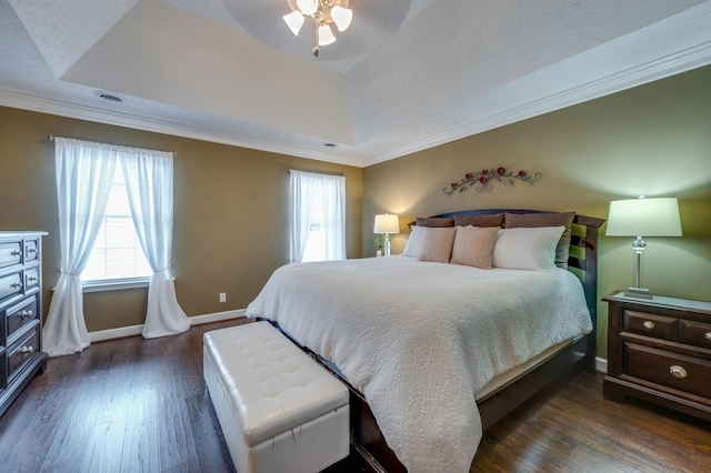 bedroom with a raised ceiling, ornamental molding, and dark hardwood / wood-style floors