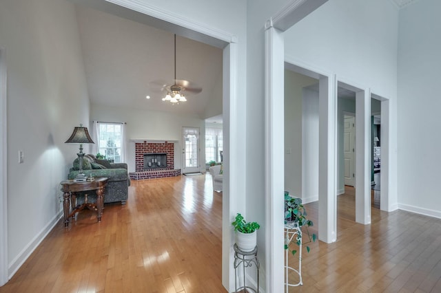 hallway with high vaulted ceiling and light wood-type flooring