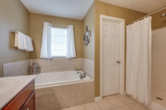 bathroom with tile patterned flooring, vanity, separate shower and tub, and a textured ceiling