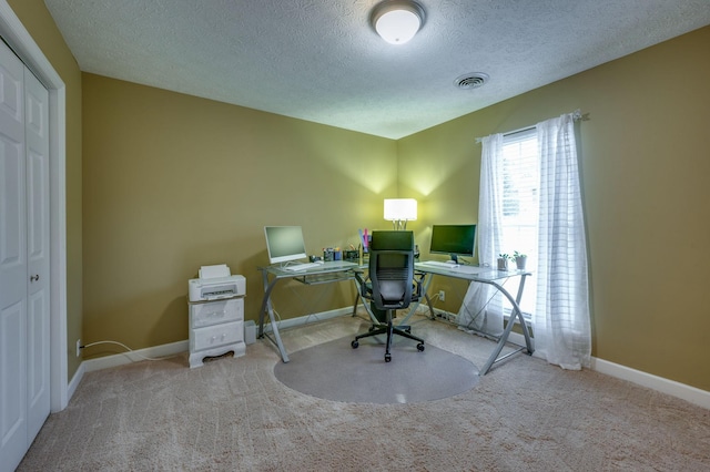 home office featuring light colored carpet and a textured ceiling