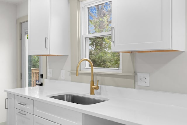 kitchen featuring white cabinetry and sink