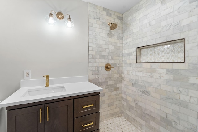 bathroom with tiled shower and vanity