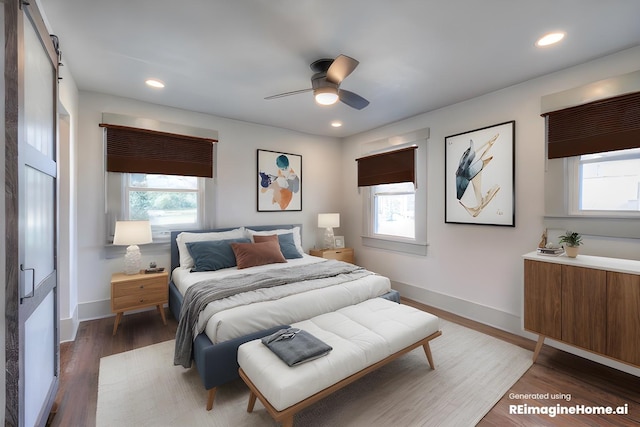 bedroom with multiple windows, a barn door, and dark hardwood / wood-style flooring