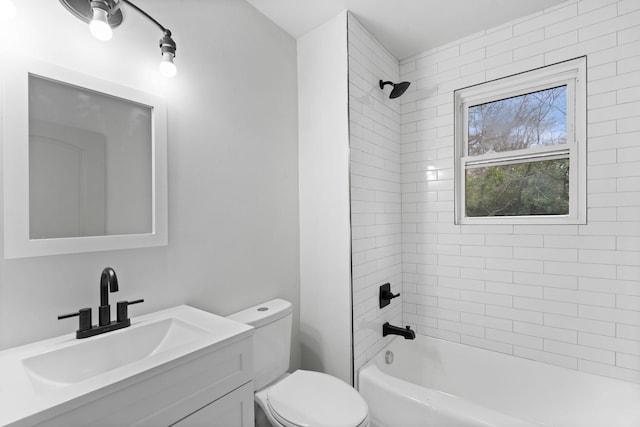 full bathroom featuring tiled shower / bath, vanity, and toilet