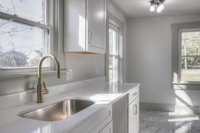 kitchen featuring white cabinetry and sink