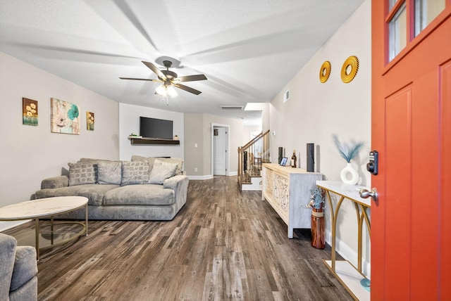 living room featuring a textured ceiling, dark wood-type flooring, and ceiling fan