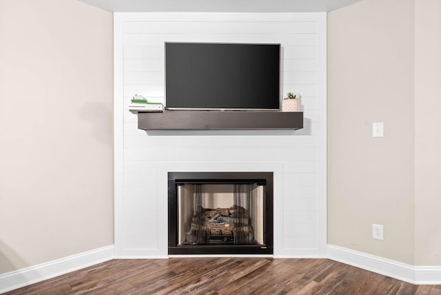 details featuring hardwood / wood-style flooring and a large fireplace