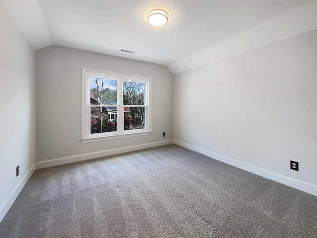 carpeted spare room with lofted ceiling