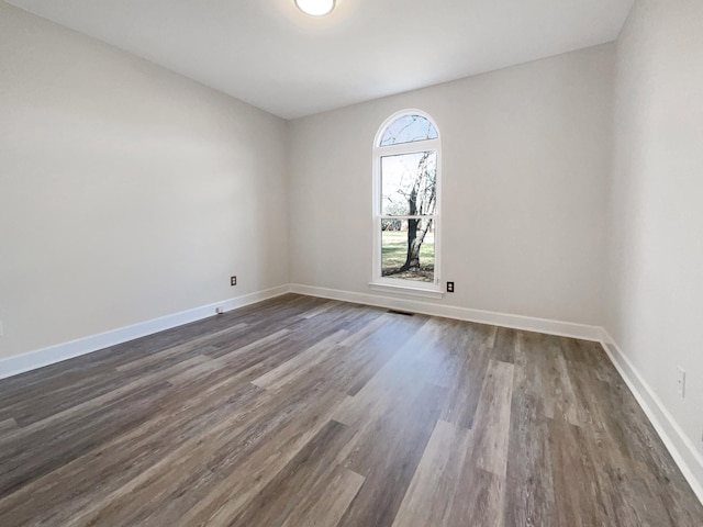 unfurnished room featuring dark wood-type flooring