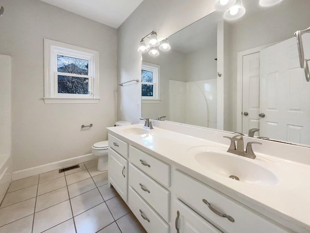 bathroom with vanity, tile patterned floors, toilet, and a shower