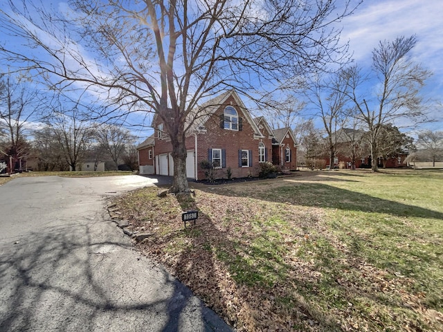 view of side of home with a yard and a garage