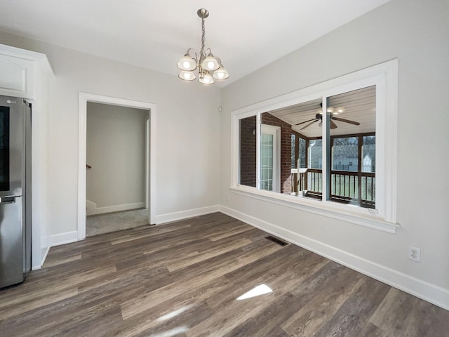 unfurnished dining area featuring dark hardwood / wood-style flooring and ceiling fan with notable chandelier