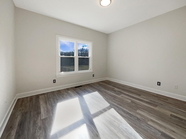 spare room with dark hardwood / wood-style flooring