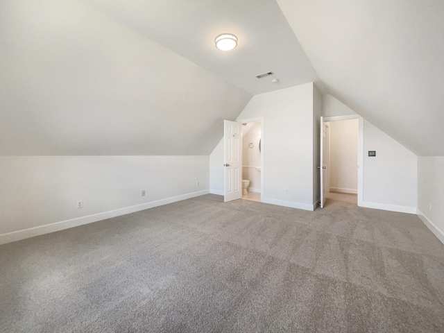 additional living space with vaulted ceiling and carpet flooring