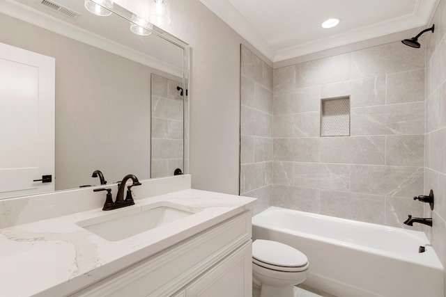 full bathroom featuring vanity, tiled shower / bath combo, ornamental molding, and toilet