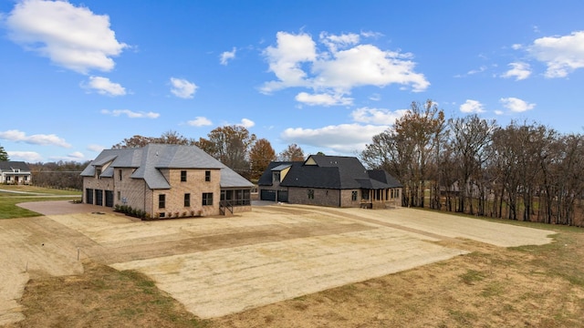 rear view of house featuring a garage and a sunroom