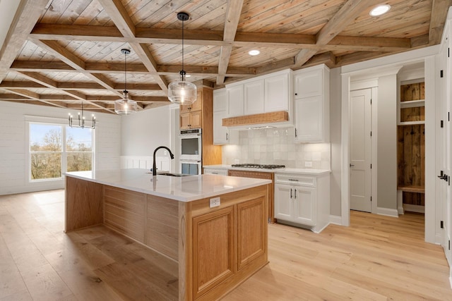 kitchen featuring white cabinets, hanging light fixtures, a large island, wood ceiling, and light hardwood / wood-style flooring